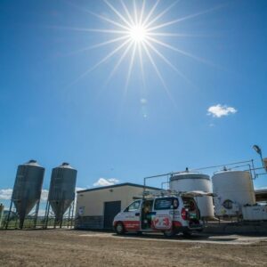 Solar installation in Hamilton and Waikato – 2E Electrical van on site at a rural farm facility under clear blue skies with strong sunlight, highlighting solar energy potential